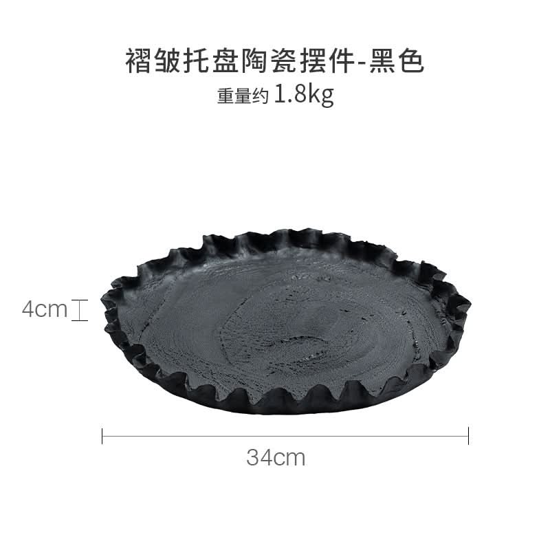 Wabi-sabi black ceramic serving dish with textured surface and ruffled edge, home decor.